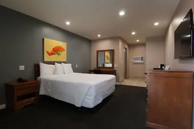 a hotel room with a bed and a television at Dunes Inn - Wilshire in Los Angeles
