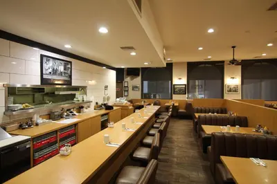 a restaurant with long tables and chairs and a kitchen at Dunes Inn - Sunset in Los Angeles