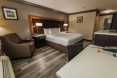 a small hotel room with a bed and a chair at Comfort Inn & Suites Near Universal - N Hollywood - Burbank in Los Angeles