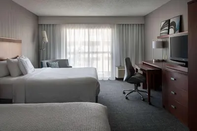 a hotel room with two beds and a desk and a television at Sonesta Select Los Angeles LAX El Segundo in El Segundo