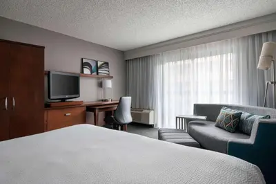 a hotel room with a bed and a desk and a television at Sonesta Select Los Angeles LAX El Segundo in El Segundo