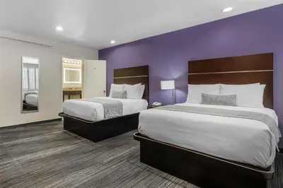 two beds in a hotel room with purple walls at SureStay Hotel by Best Western Beverly Hills West LA in Los Angeles