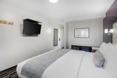 a bedroom with a white bed and a flat screen tv at SureStay Hotel by Best Western Beverly Hills West LA in Los Angeles