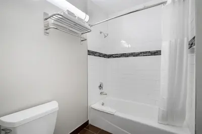 a white bathroom with a tub and a toilet at SureStay Hotel by Best Western Beverly Hills West LA in Los Angeles