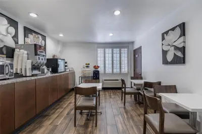 a restaurant with tables and chairs and a kitchen at SureStay Hotel by Best Western Beverly Hills West LA in Los Angeles