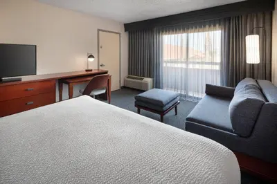 a hotel room with a bed and a couch and a desk at Courtyard by Marriott Los Angeles Hacienda Heights Orange County in Hacienda Heights