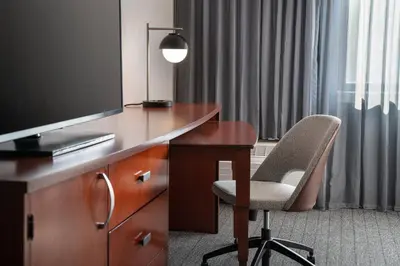 a hotel room with a desk with a television and a chair at Courtyard by Marriott Los Angeles Hacienda Heights Orange County in Hacienda Heights