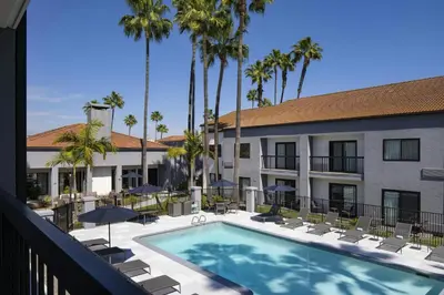 a view of a hotel with a swimming pool and palm trees at Courtyard by Marriott Los Angeles Hacienda Heights Orange County in Hacienda Heights