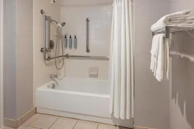 a bathroom with a white tub and a shower at Courtyard by Marriott Baldwin Park in Baldwin Park