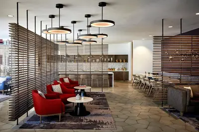 a restaurant with red chairs and tables and a bar at Ventura Beach Marriott in Ventura