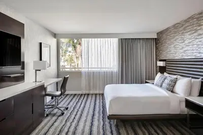 a hotel room with a bed and a desk and a television at Ventura Beach Marriott in Ventura