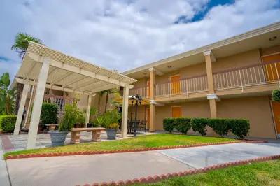 a building with a porch and a bench in front of it at Howard Johnson by Wyndham Buena Park in Buena Park