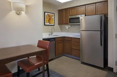 a kitchen with a refrigerator and a table with a chair at Residence Inn Anaheim Hills Yorba Linda in Anaheim