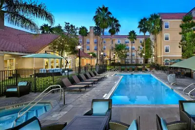 a pool at a hotel with chairs and a building at Residence Inn Anaheim Hills Yorba Linda in Anaheim