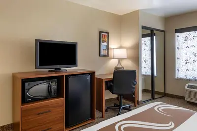 a room with a tv and a desk with a computer at Quality Inn Placentia Anaheim Fullerton in Placentia
