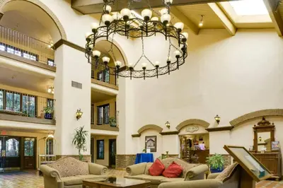 a large lobby with a chandelier and couches at The Buena Park Grand Hotel & Suites in Buena Park