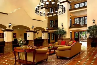 a large living room with couches and a chandelier at The Buena Park Grand Hotel & Suites in Buena Park