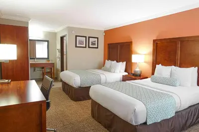 a hotel room with two beds and a desk at The Hills Inn Eagle Rock - Near Old Town Pasadena in Los Angeles