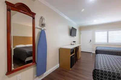 a bedroom with a mirror and a bed and a sink at Hollywood City Inn in Los Angeles
