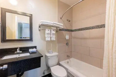 a bathroom with a toilet and a sink and a tub at Hollywood City Inn in Los Angeles