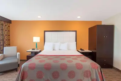 a hotel room with a bed and a chair at Ramada by Wyndham Culver City in Los Angeles