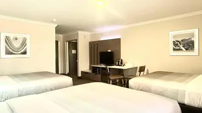 a hotel room with two beds and a desk at Quality Inn & Suites Los Angeles Airport - Stadium District in Inglewood