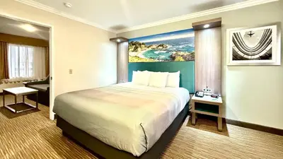 a hotel room with a large bed and a bathroom at Quality Inn & Suites Los Angeles Airport - Stadium District in Inglewood