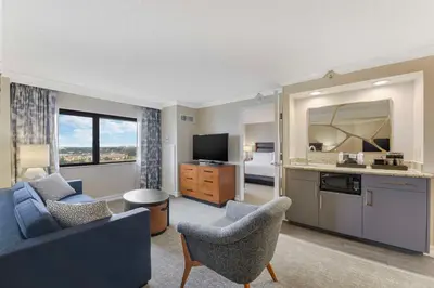 a living room with a couch and chairs and a television at Embassy Suites by Hilton Anaheim-Orange in Anaheim