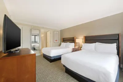 a hotel room with two beds and a flat screen tv at Embassy Suites by Hilton Anaheim-Orange in Anaheim