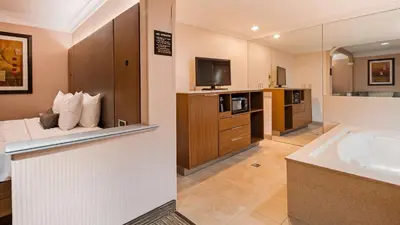 a large bathroom with a bed and a television at Best Western Plus Suites Hotel - LAX Airport LA Stadium in Inglewood