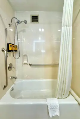 a white bath tub in a bathroom with a shower at Best Western Plus Suites Hotel - LAX Airport LA Stadium in Inglewood