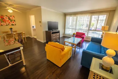 a living room with a blue couch and a yellow chair at Cal Mar Hotel Suites in Los Angeles