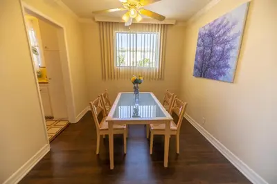 a dining room with a table with chairs and a ceiling fan at Cal Mar Hotel Suites in Los Angeles