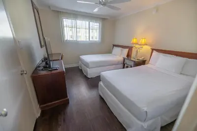 a hotel room with two beds and a television at Cal Mar Hotel Suites in Los Angeles