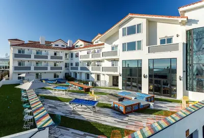 an apartment building with a swimming pool and a patio at Hotel Hermosa in Hermosa Beach