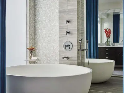 a white bath tub in a bathroom with a shower at Fairmont Miramar Hotel & Bungalows in Los Angeles
