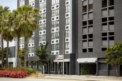 an office building with palm trees in front of it at Hilton Garden Inn LAX Los Angeles Airport in Los Angeles