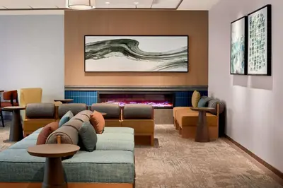 a living room with a couch and a fireplace at Hilton Garden Inn LAX Los Angeles Airport in Los Angeles