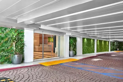 a building with a hallway with plants on the walls at Hilton Garden Inn LAX Los Angeles Airport in Los Angeles