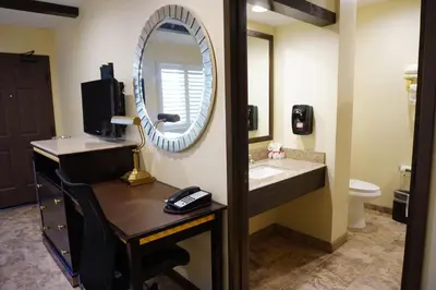 a bathroom with a sink and a mirror at Tuscan Garden Inn in Los Angeles