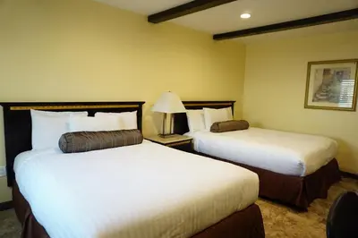 a hotel room with two beds and a lamp at Tuscan Garden Inn in Los Angeles