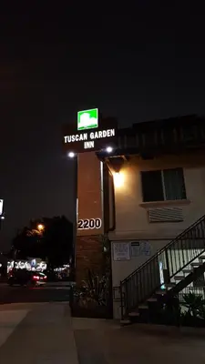 a sign for a tuscan garden inn at night at Tuscan Garden Inn in Los Angeles