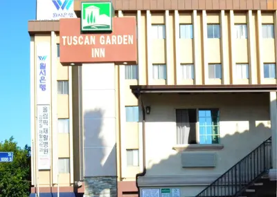 a building with a sign that reads irisan garden inn at Tuscan Garden Inn in Los Angeles