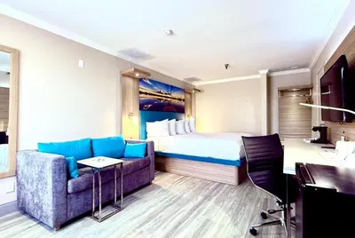 a hotel room with a bed and a couch at Days Inn by Wyndham Los Angeles LAX South Bay Beach City LA in Lawndale