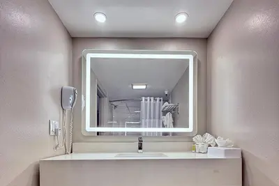 a bathroom with a sink and a mirror at Days Inn by Wyndham Los Angeles LAX South Bay Beach City LA in Lawndale