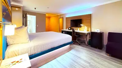 a hotel room with a bed and a desk at Days Inn by Wyndham Los Angeles LAX South Bay Beach City LA in Lawndale