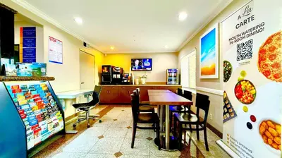 a fast food restaurant with a table and chairs at Days Inn by Wyndham Los Angeles LAX South Bay Beach City LA in Lawndale