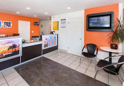 a waiting room with a counter and a tv on the wall at Motel 6-Rosemead, CA - Los Angeles in Rosemead