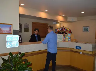two men standing at a counter in a store at Jolly Roger Hotel in Los Angeles
