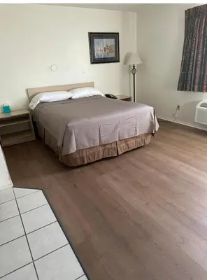 a bedroom with a bed and a wooden floor at Jolly Roger Hotel in Los Angeles